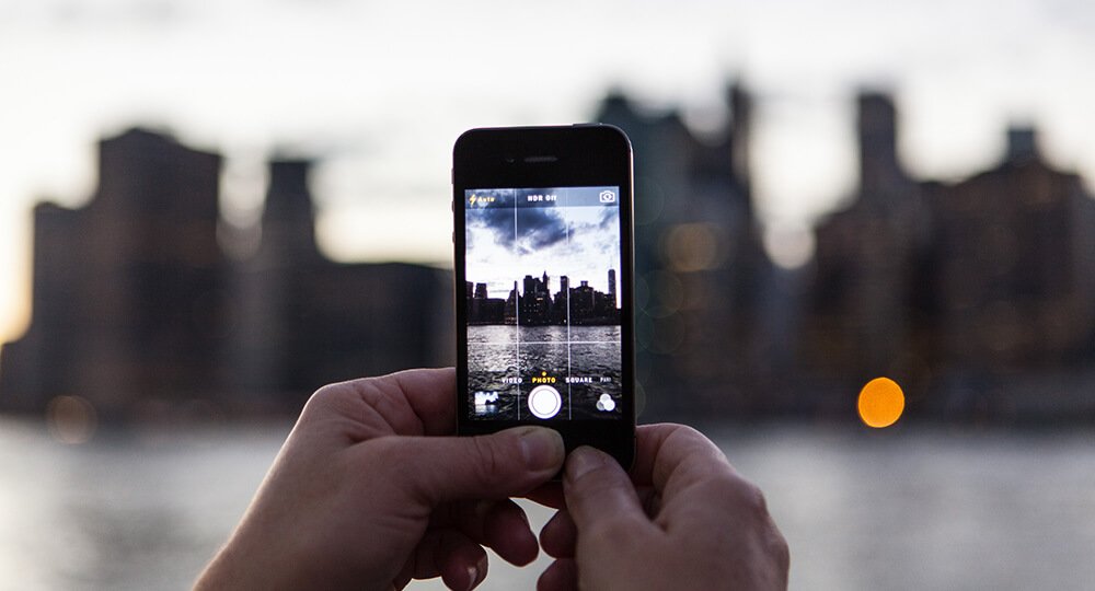Jemand fotografiert die New Yorker Skyline mit dem Smartphone.