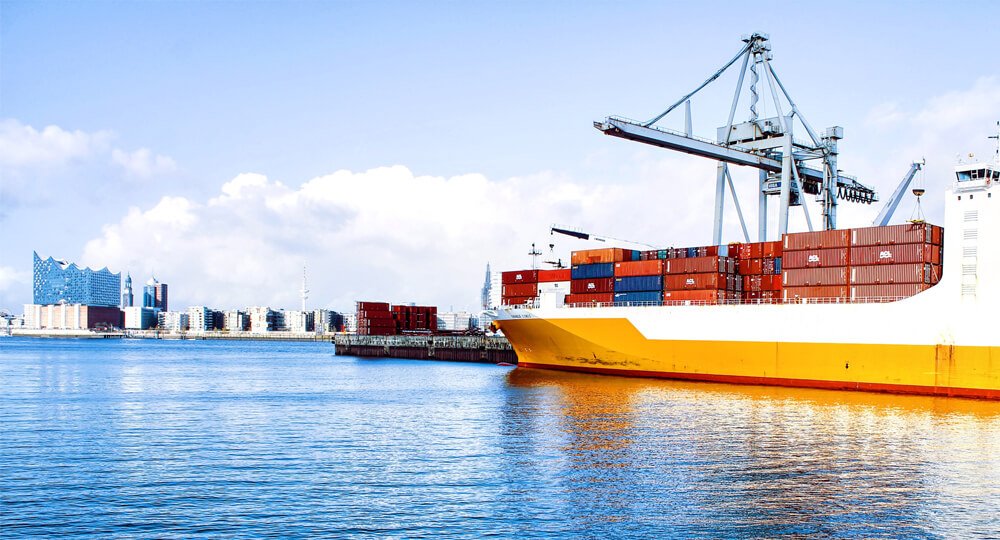 Ein Schlepper zieht ein Containerschiff in den Hamburger Hafen.